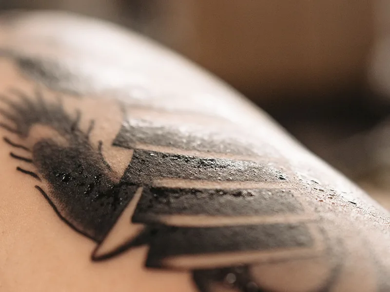 Close-up of a freshly finished black tattoo at the start of tattoo healing