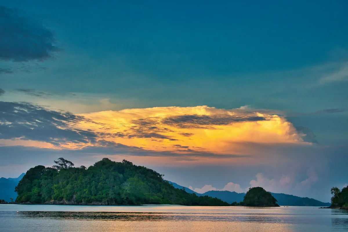 Island silhouette under a sunset sky in Langkawi, where a tattoo session works best at the end of the trip