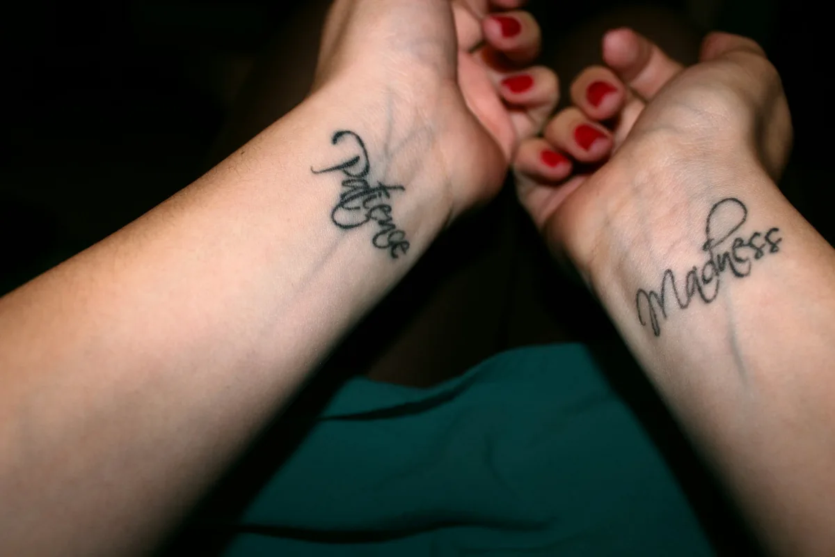 Two small script tattoos on a pair of wrists, a classic among small tattoo ideas