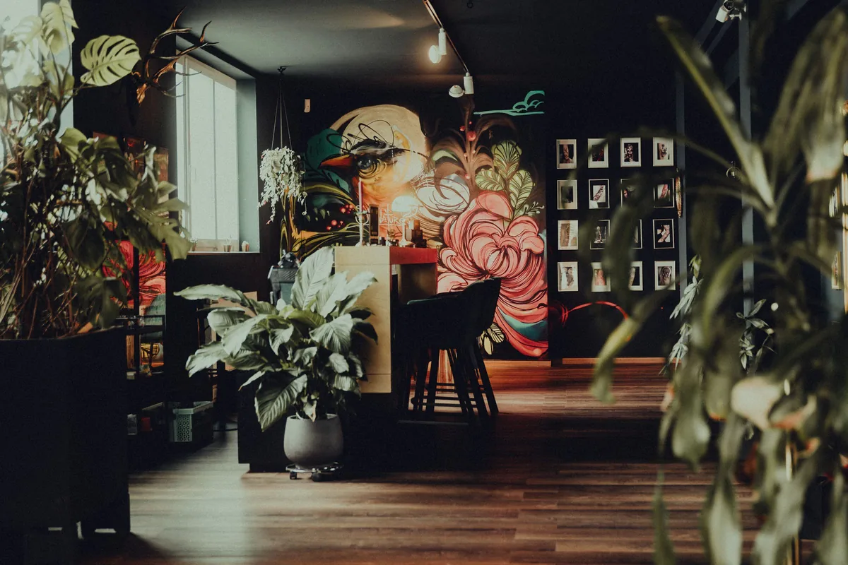 Tattoo parlour with a painted wall mural, plants and framed art, typical of a tattoo shop in Selangor